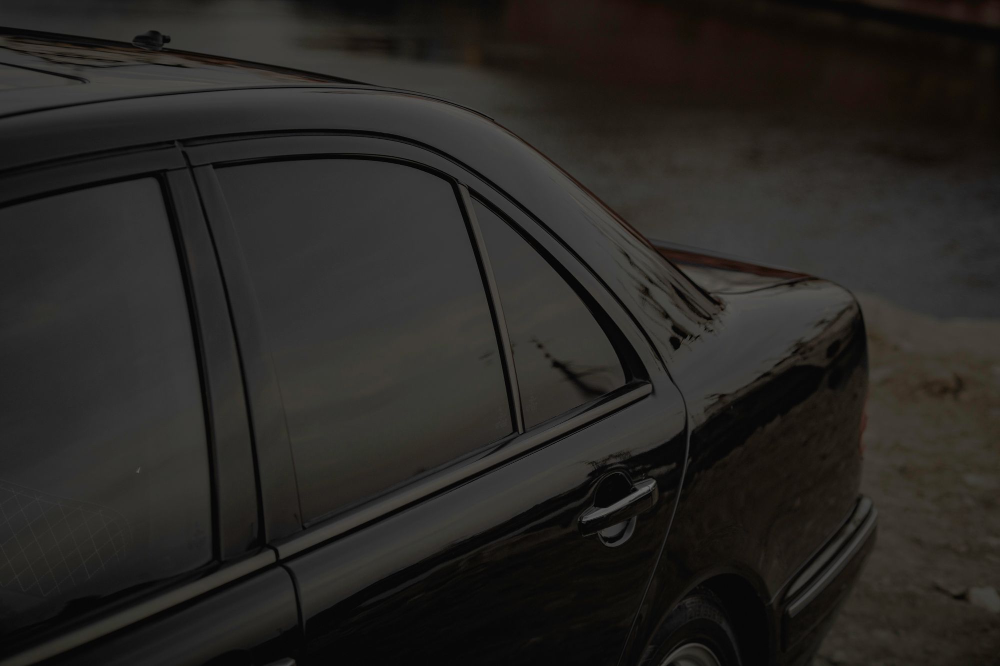 Close-up of the tinted side windows on a black sedan