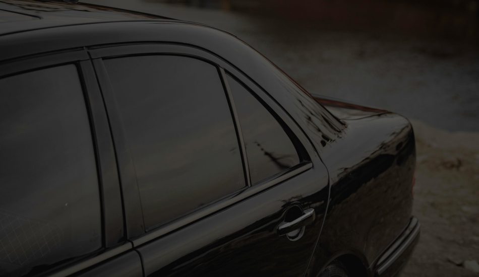 Close-up of the tinted side windows on a black sedan